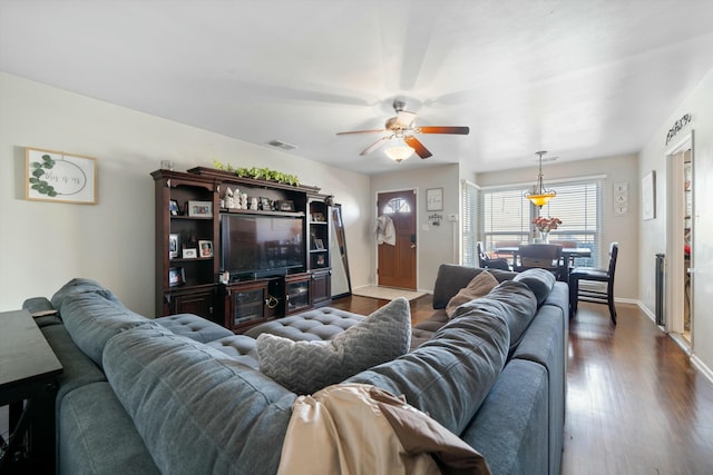 living room featuring ceiling fan and dark wood-type flooring