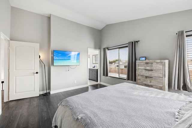 bedroom with dark hardwood / wood-style floors, lofted ceiling, and ensuite bathroom