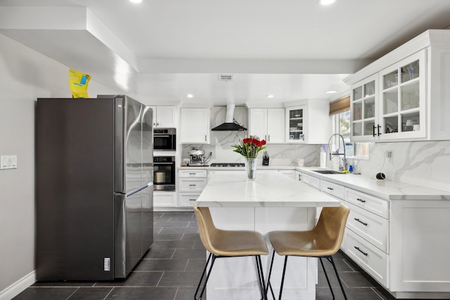 kitchen featuring white cabinets, light stone counters, sink, and stainless steel refrigerator