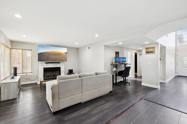 living room featuring a fireplace, dark hardwood / wood-style flooring, and a healthy amount of sunlight