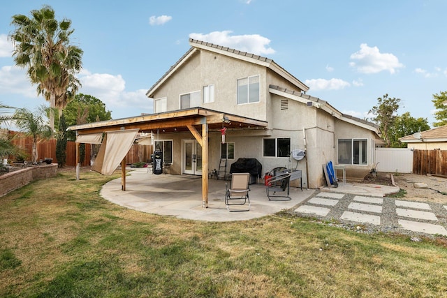 back of property with a lawn and a patio