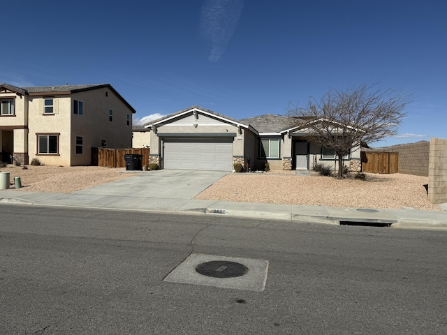 view of front of house with a garage, driveway, fence, and stucco siding