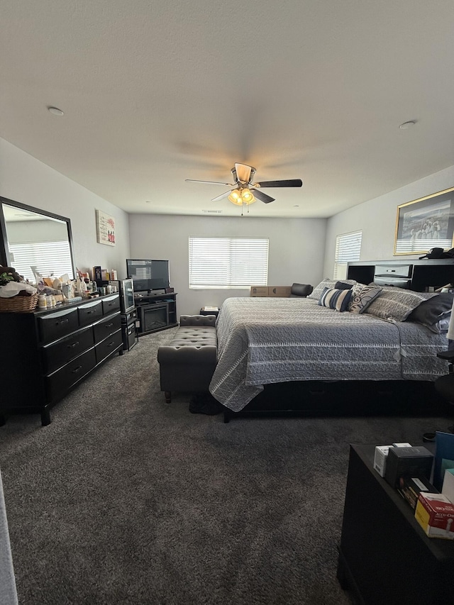 bedroom featuring dark carpet and a ceiling fan