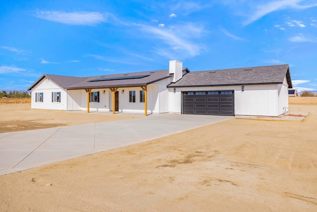 view of front facade featuring a garage and solar panels