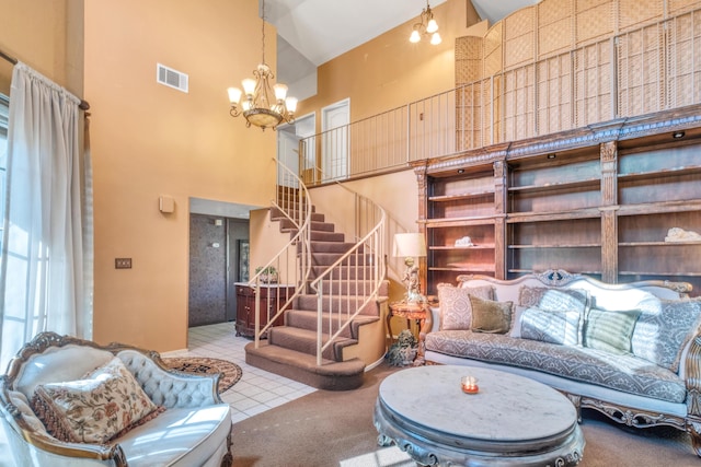 living area with a chandelier, visible vents, stairway, and high vaulted ceiling