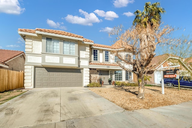 mediterranean / spanish-style house featuring stucco siding, driveway, a tile roof, and a garage