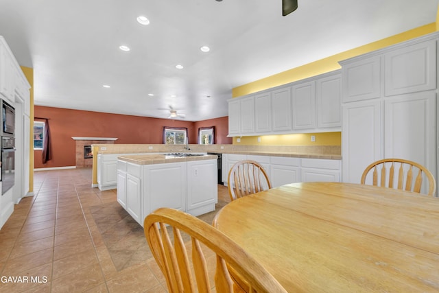 8433 Prospect St, Mojave, CA 93501 - kitchen featuring ceiling fan, recessed lighting, tile counters, a kitchen island, and white cabinetry
