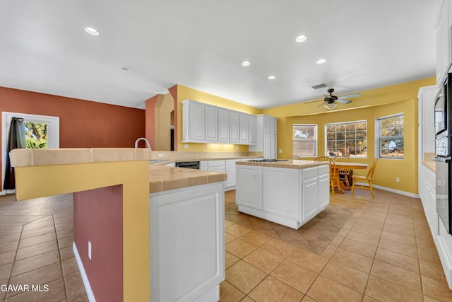 8433 Prospect St, Mojave, CA 93501 - kitchen with tile countertops, a peninsula, a center island, white cabinetry, and recessed lighting