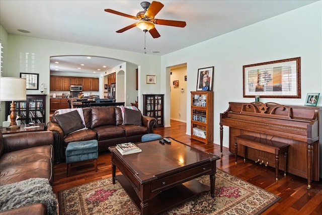 living room featuring dark wood-type flooring and ceiling fan