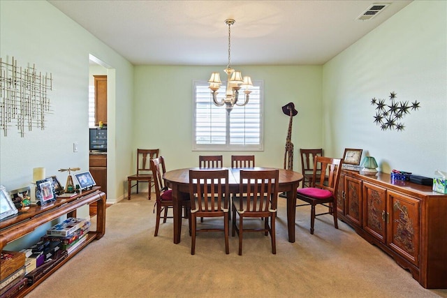 dining room featuring light carpet and an inviting chandelier