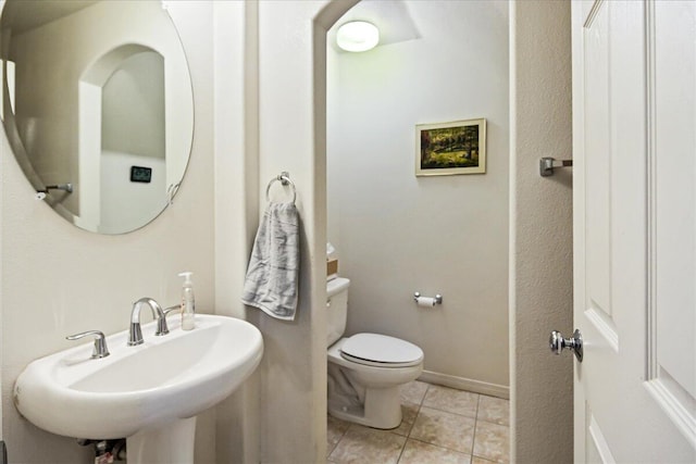 bathroom with tile patterned flooring, sink, and toilet