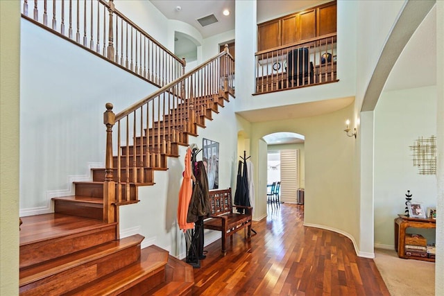 staircase featuring hardwood / wood-style floors and a high ceiling