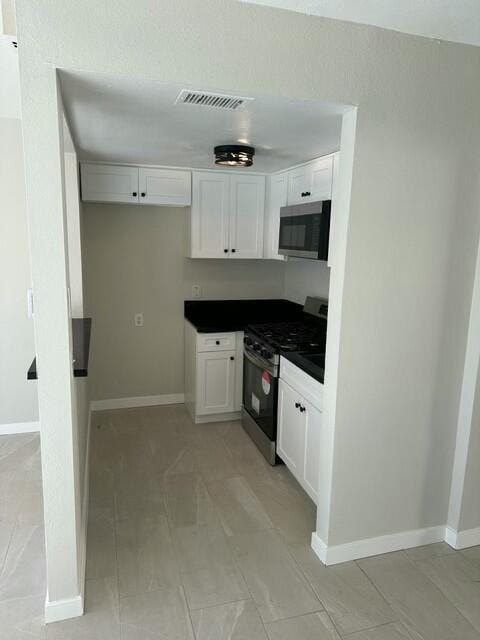 kitchen with appliances with stainless steel finishes and white cabinetry