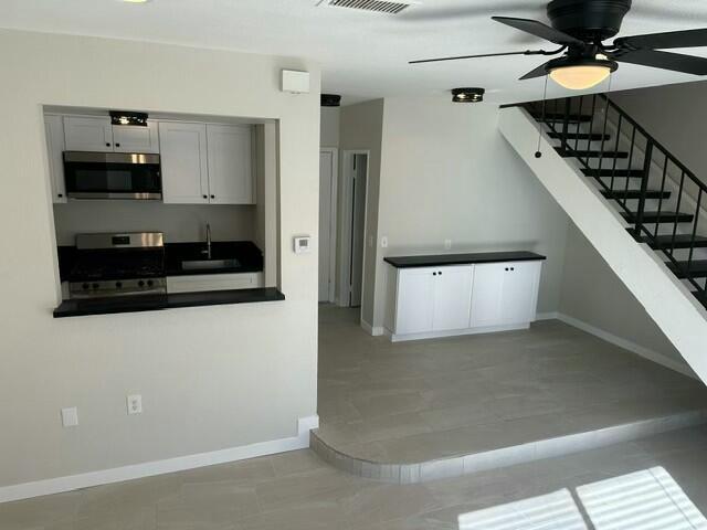 kitchen featuring ceiling fan, sink, stainless steel appliances, and light tile patterned flooring