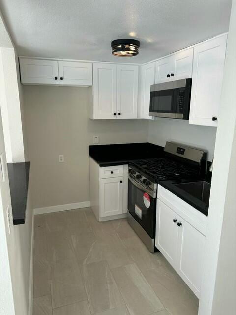 kitchen featuring appliances with stainless steel finishes, sink, and white cabinetry