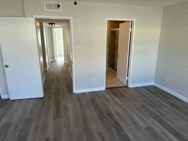 unfurnished bedroom with dark hardwood / wood-style flooring