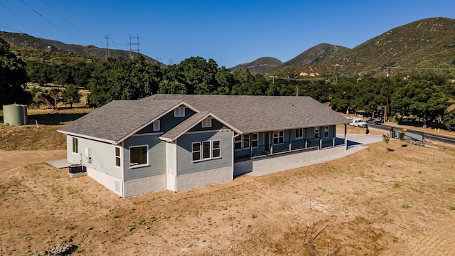 view of front of house featuring a porch, central air condition unit, and a mountain view