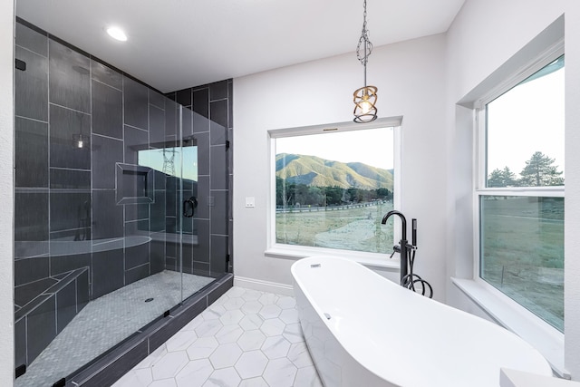 bathroom featuring a healthy amount of sunlight, tile patterned floors, a mountain view, and shower with separate bathtub