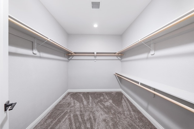 walk in closet with dark carpet