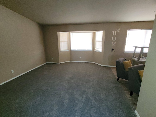 unfurnished living room with dark carpet and a healthy amount of sunlight