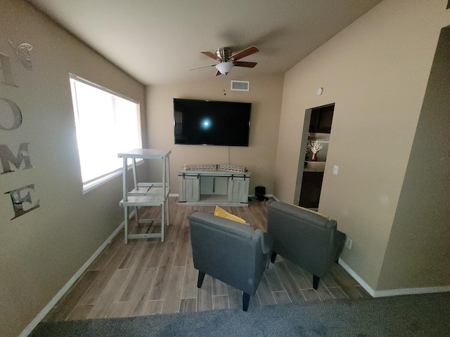 living room with ceiling fan, lofted ceiling, and light hardwood / wood-style floors