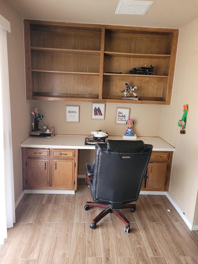 home office featuring built in desk and light wood-type flooring