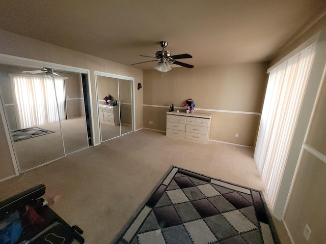 unfurnished bedroom featuring carpet, two closets, and ceiling fan