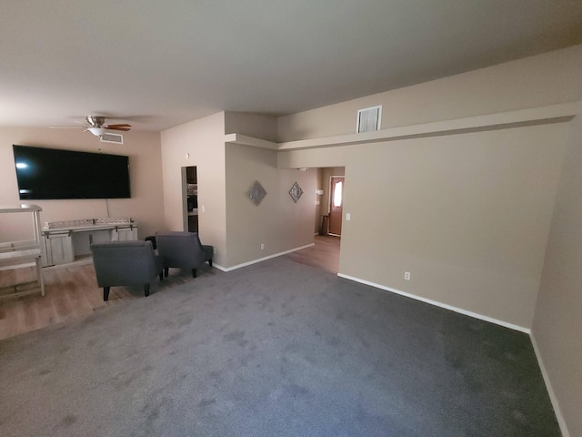 unfurnished living room with carpet and ceiling fan