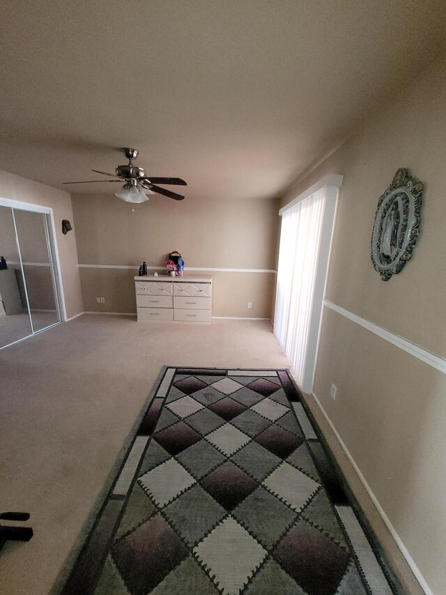 unfurnished bedroom featuring dark colored carpet and ceiling fan