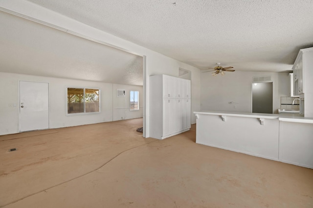 interior space with light carpet, a textured ceiling, ceiling fan, and sink