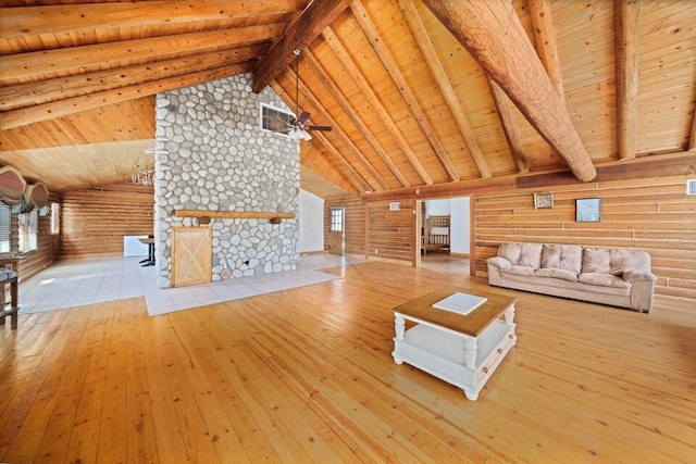 unfurnished living room with light hardwood / wood-style flooring, ceiling fan, log walls, beam ceiling, and wood ceiling