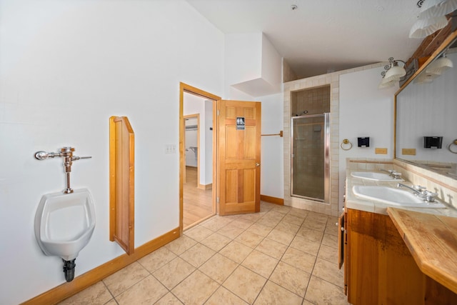 bathroom with tile patterned floors, a shower with door, and vanity