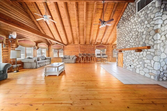 unfurnished living room with rustic walls, beamed ceiling, wood ceiling, and light wood-type flooring