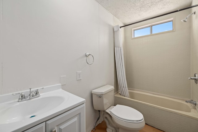 full bathroom featuring shower / bath combo with shower curtain, vanity, a textured ceiling, and toilet