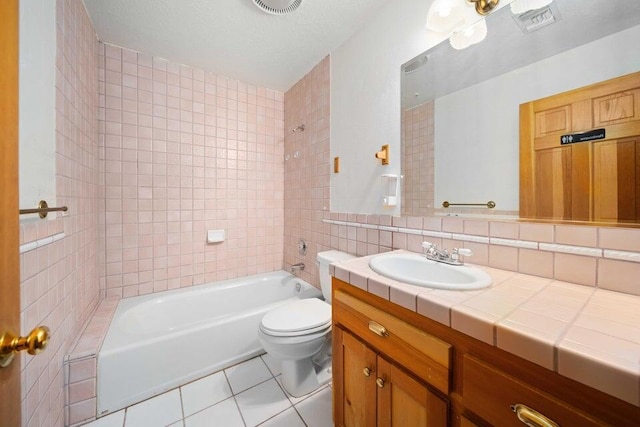 full bathroom featuring vanity, backsplash, tile patterned flooring, tiled shower / bath combo, and toilet