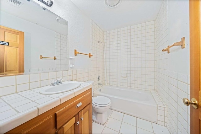 full bathroom featuring vanity, backsplash, tile patterned flooring, toilet, and tile walls