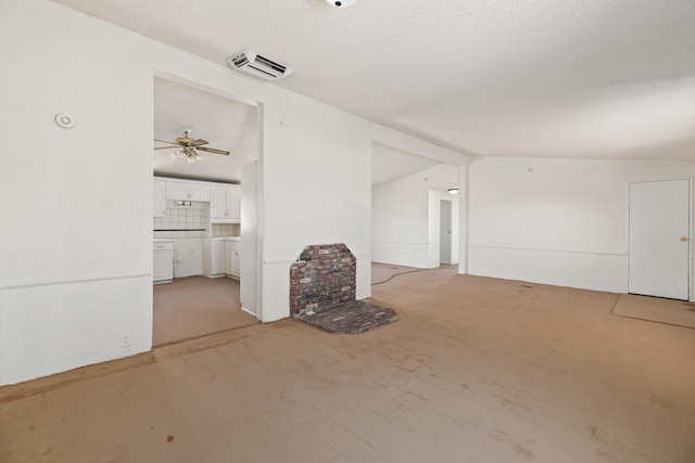 unfurnished living room featuring a textured ceiling, ceiling fan, light colored carpet, and vaulted ceiling