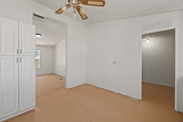 carpeted empty room with a textured ceiling and ceiling fan