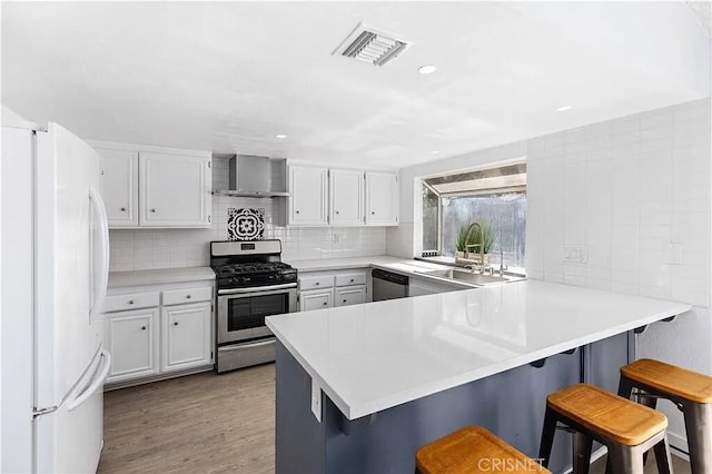 kitchen with a kitchen bar, kitchen peninsula, sink, and stainless steel appliances