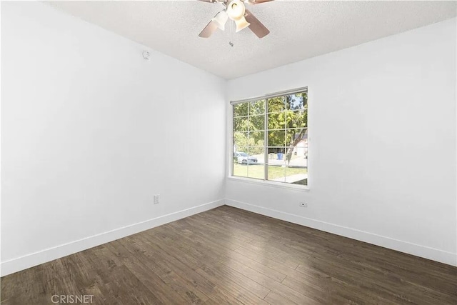 spare room featuring ceiling fan and dark wood-type flooring