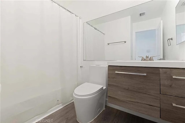 full bathroom featuring vanity, toilet, wood-type flooring, and shower / tub combo with curtain