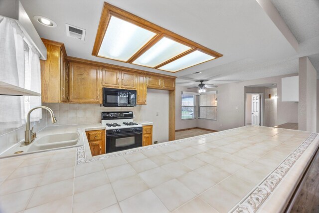 1086 Hickory Ave, Tehachapi, CA 93561 - kitchen with visible vents, a sink, black microwave, decorative backsplash, and range with gas stovetop