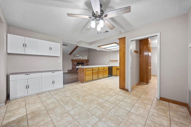 1086 Hickory Ave, Tehachapi, CA 93561 - kitchen with a peninsula, a fireplace, a textured ceiling, and ceiling fan