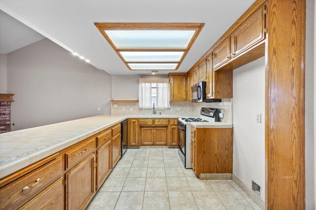 1086 Hickory Ave, Tehachapi, CA 93561 - kitchen featuring black appliances, brown cabinets, tasteful backsplash, and a sink