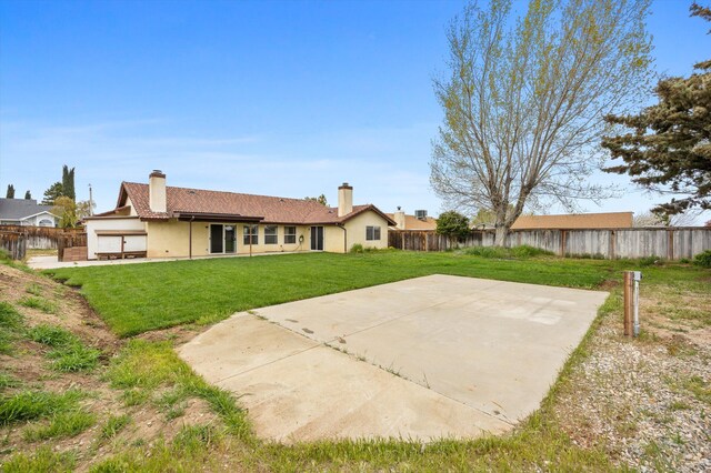1086 Hickory Ave, Tehachapi, CA 93561 - back of house featuring a fenced backyard, stucco siding, a patio, and a lawn