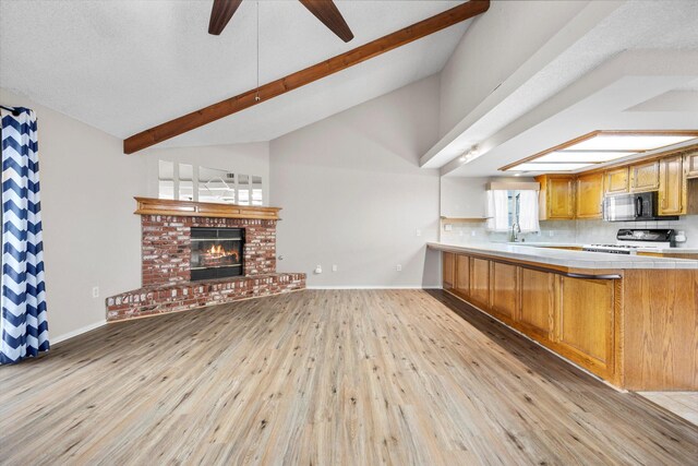 1086 Hickory Ave, Tehachapi, CA 93561 - kitchen featuring tile counters, black microwave, range, beamed ceiling, and light wood-style flooring
