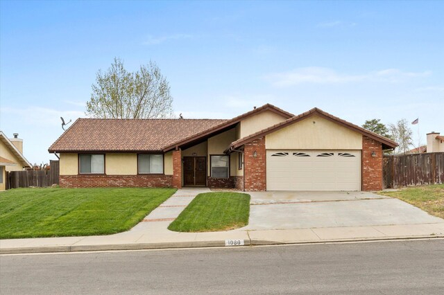 1086 Hickory Ave, Tehachapi, CA 93561 - view of front of home featuring an attached garage, fence, a front yard, stucco siding, and brick siding