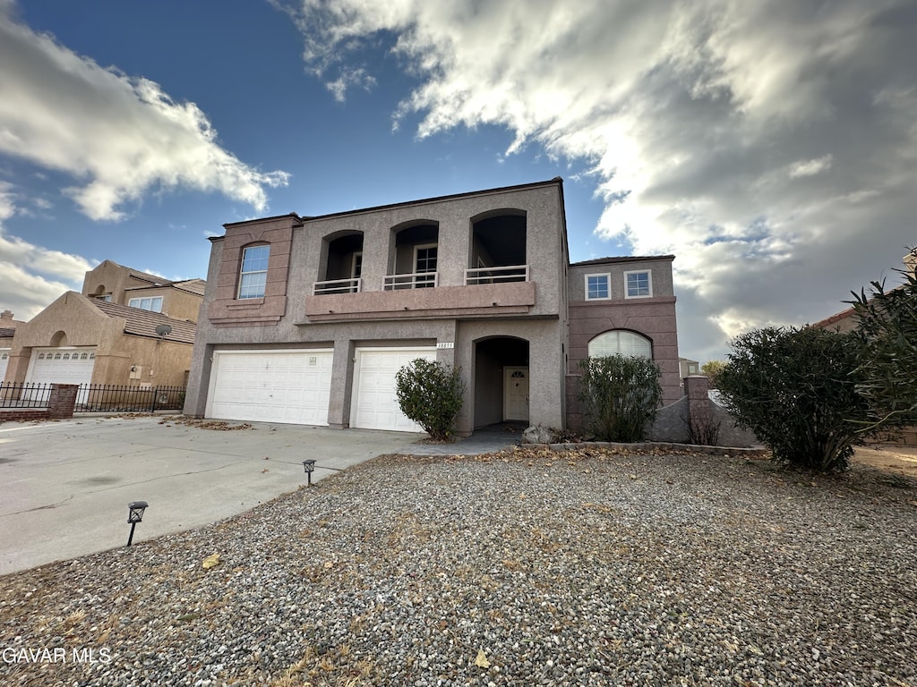 38855 Calistoga St, Palmdale, CA 93551 - view of front of property featuring a balcony, concrete driveway, an attached garage, and stucco siding