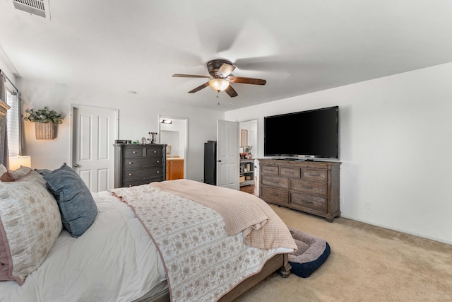 carpeted bedroom featuring ceiling fan and ensuite bath