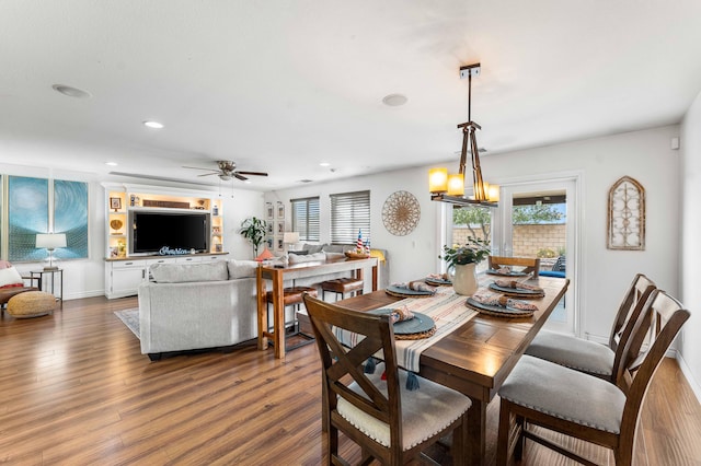 dining space featuring dark hardwood / wood-style flooring and ceiling fan with notable chandelier